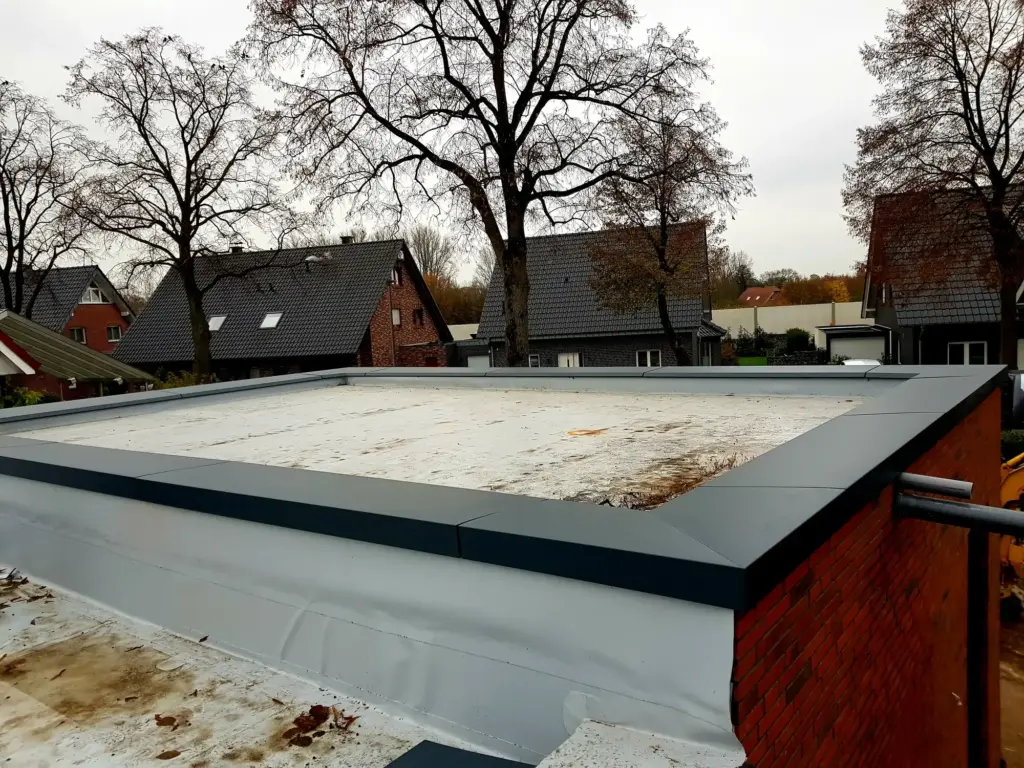 Anthrazitfarbene Aluminium-Attikaabdeckung mit ausgebildeten Ecken auf einem Flachdach