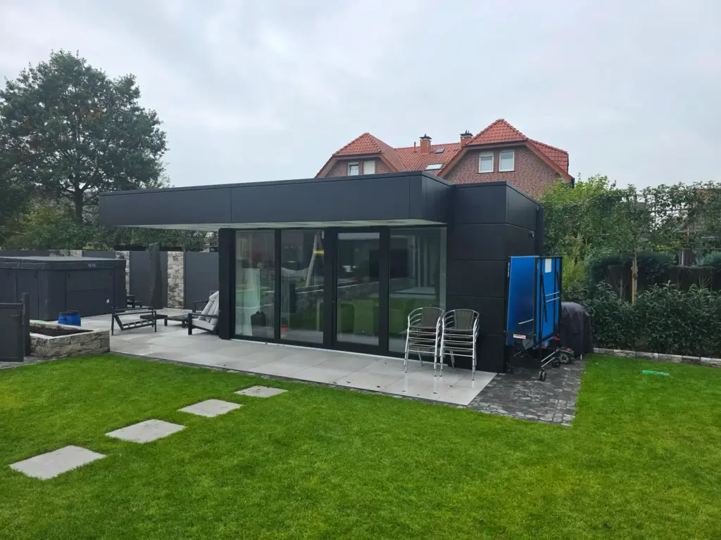 Fertig verkleidetes Gartengebäude mit anthrazitfarbenen Aluminiumkassetten und klaren Fugen