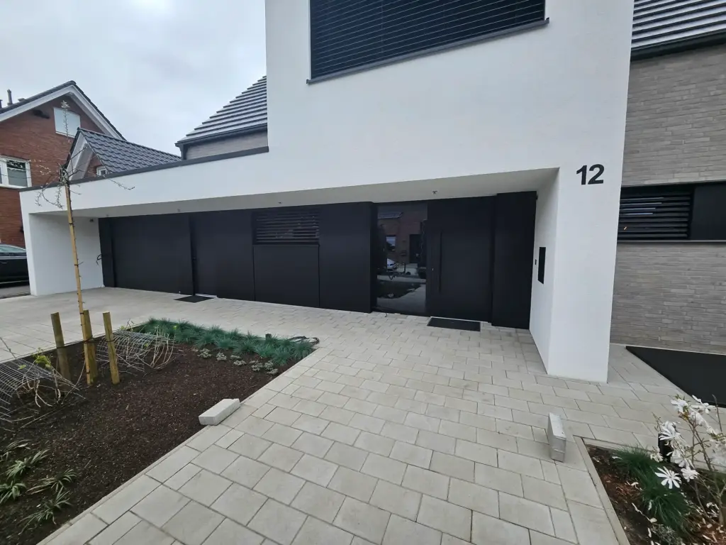 Anthrazitfarbene Aluminiumverkleidung an Haustür, Garage und Eingangsbereich