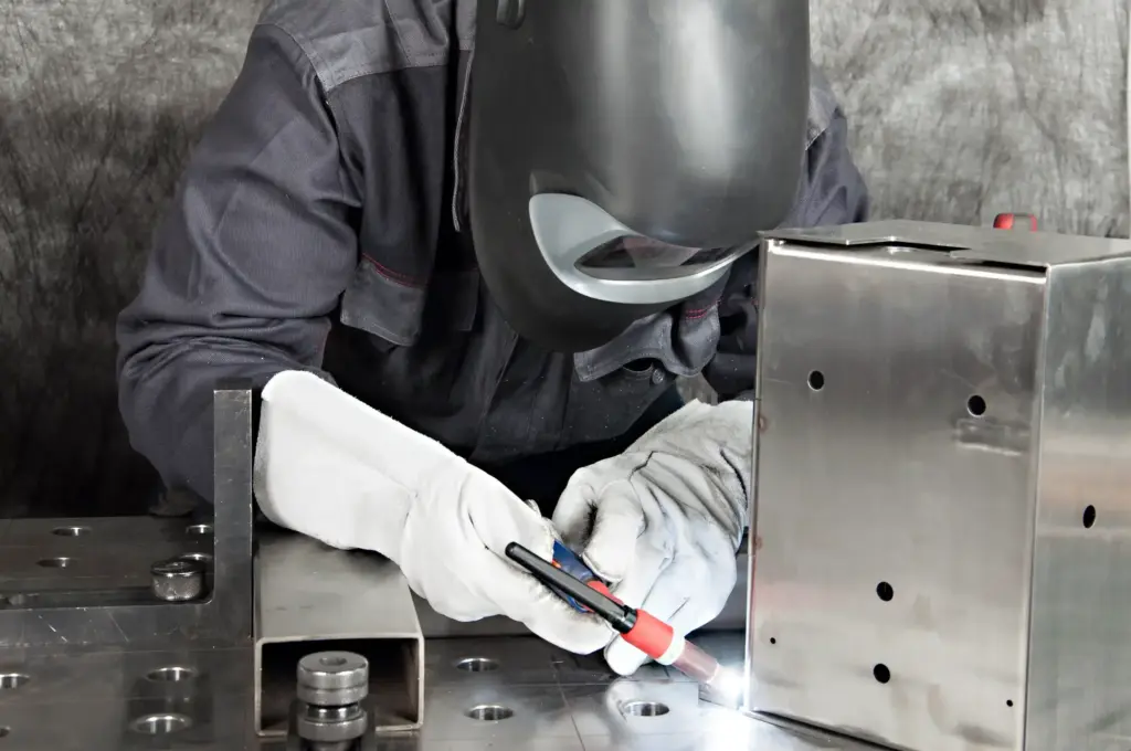 Fachkraft beim WIG-Schweißen eines Aluminiumbauteils am Schweißtisch